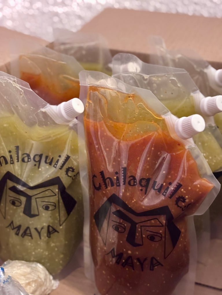 Chilled Mayan beverages in clear pouches with straws, showing golden and reddish-brown colored drinks stacked together